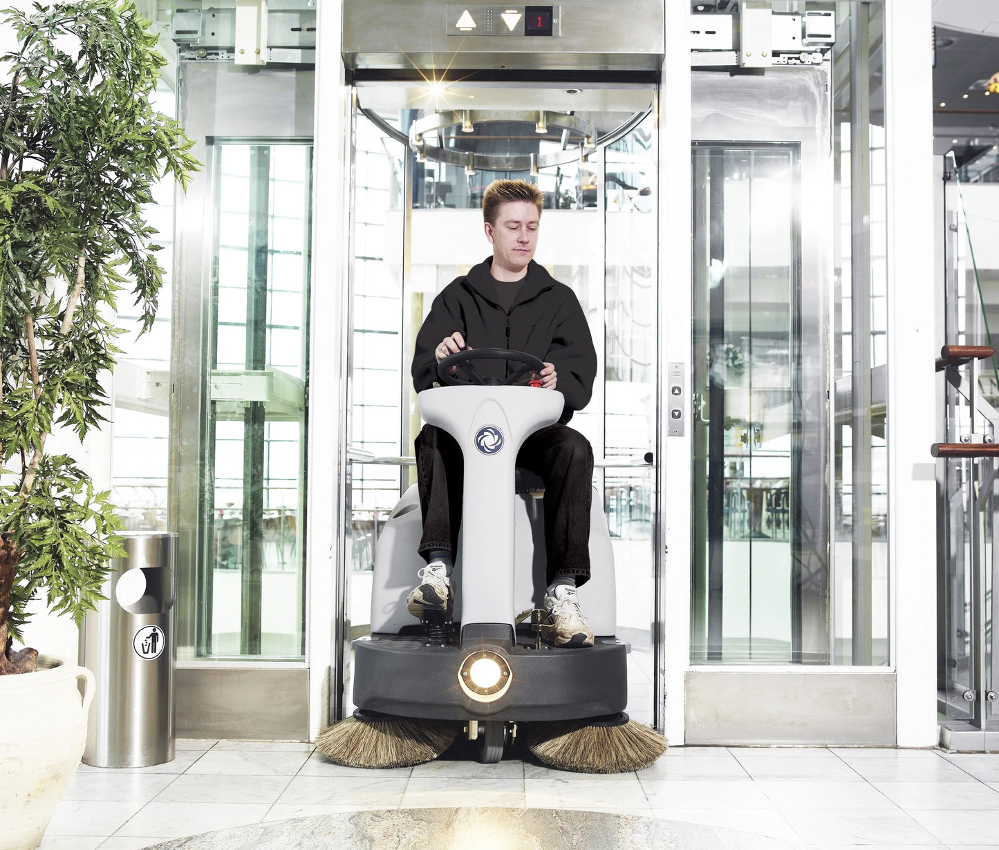 Ein Mann, der mit dem Nilfisk SR1000S in einem Fahrstuhl fährt